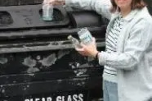 Caroline putting glass in the bottle bank