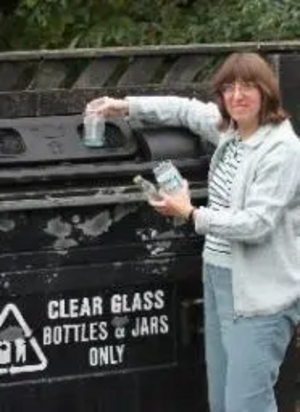 Caroline putting glass in the bottle bank